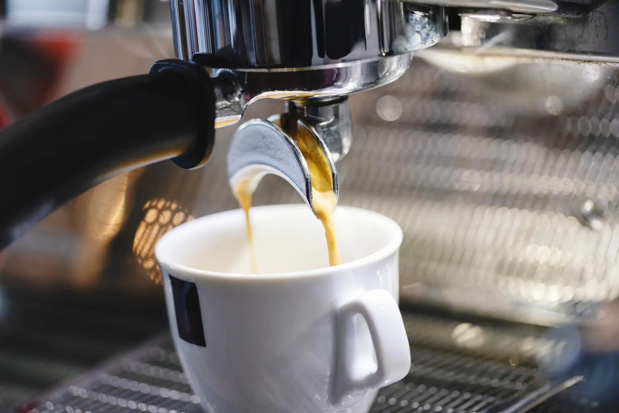 Einschenken von Espresso aus der Maschine in eine Tasse.